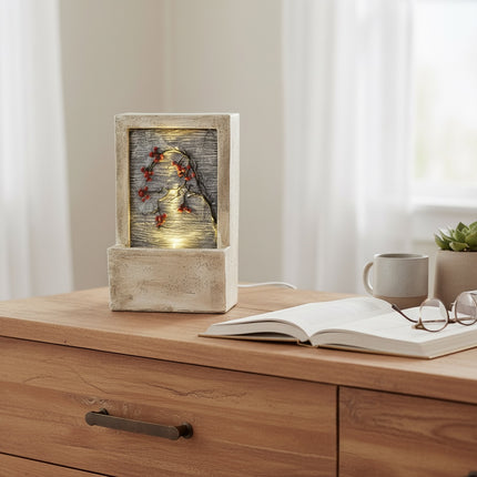 DekoSturm beige polyresin tabletop water feature with warm white LED lights and a branch with red berries. Includes a stone finish and measures 23x9.5x15cm.