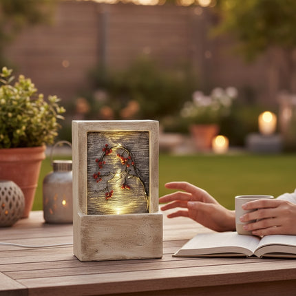 DekoSturm beige polyresin water feature with illuminated branches and red berries, 23x9.5x15cm.